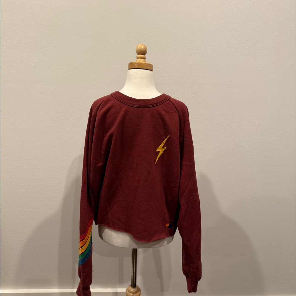 AV Maroon crewneck with Lightning Bolt and rainbow striped design